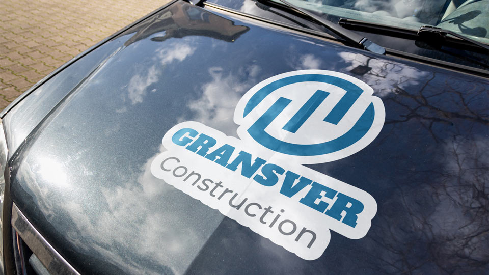 Custom-cut business car hood decal with blue logo graphics.